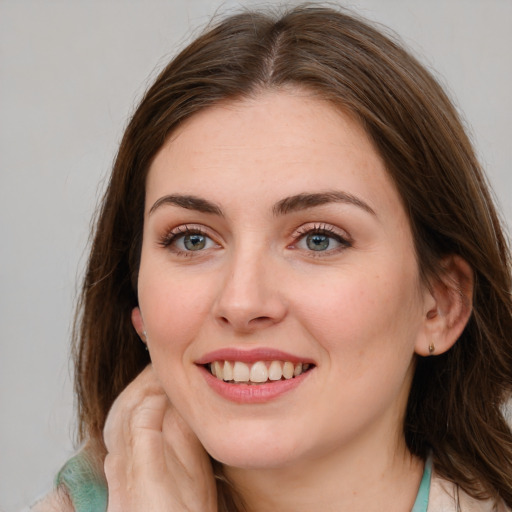 Joyful white young-adult female with long  brown hair and blue eyes