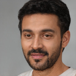 Joyful latino young-adult male with short  black hair and brown eyes