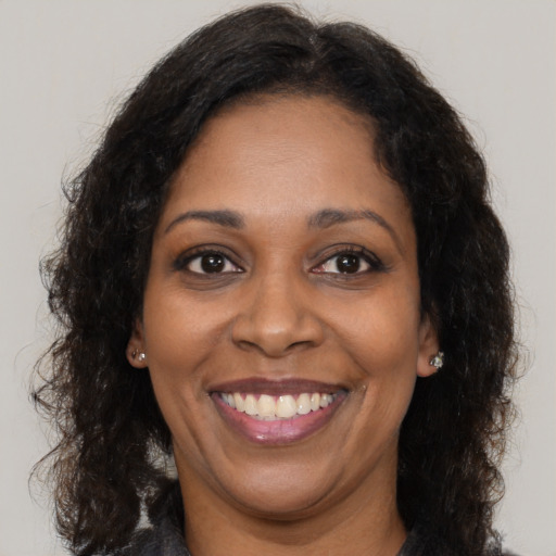 Joyful black adult female with long  brown hair and brown eyes