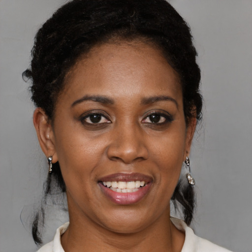 Joyful black young-adult female with short  black hair and brown eyes