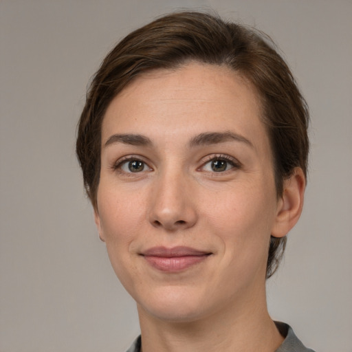 Joyful white young-adult female with short  brown hair and grey eyes