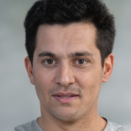 Joyful white young-adult male with short  black hair and brown eyes