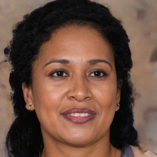 Joyful black adult female with long  brown hair and brown eyes