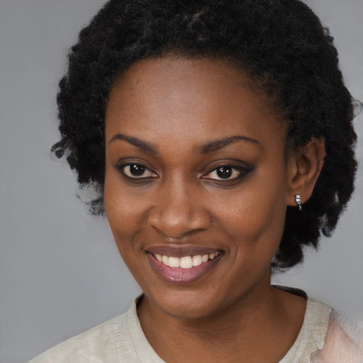 Joyful black young-adult female with short  black hair and brown eyes