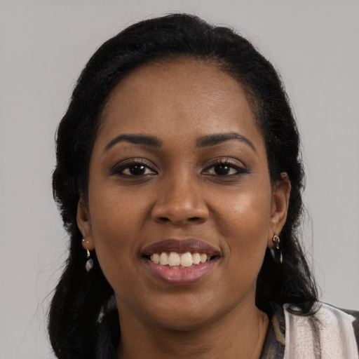 Joyful black young-adult female with long  black hair and brown eyes