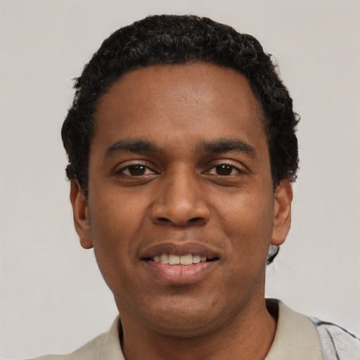 Joyful black young-adult male with short  black hair and brown eyes