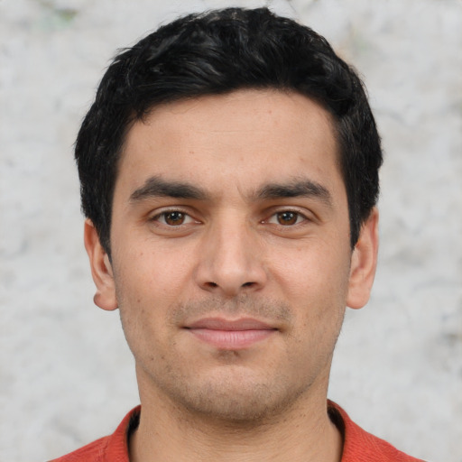 Joyful white young-adult male with short  black hair and brown eyes