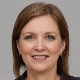 Joyful white adult female with medium  brown hair and grey eyes