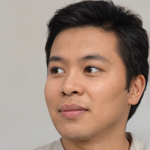 Joyful asian young-adult male with short  black hair and brown eyes