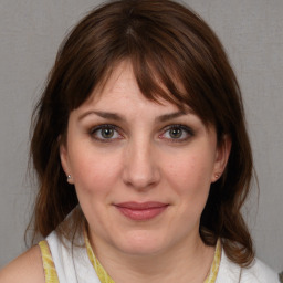 Joyful white young-adult female with medium  brown hair and blue eyes