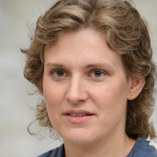 Joyful white young-adult female with medium  brown hair and blue eyes