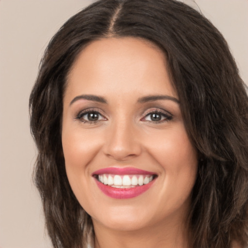 Joyful white young-adult female with long  brown hair and brown eyes