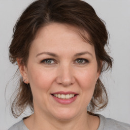 Joyful white adult female with medium  brown hair and grey eyes