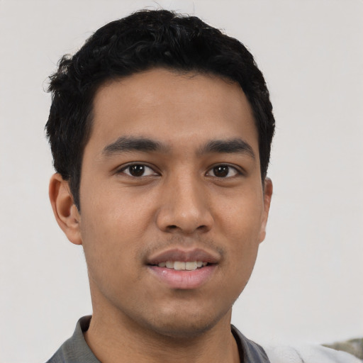 Joyful latino young-adult male with short  black hair and brown eyes