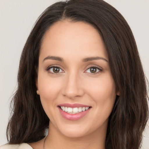 Joyful white young-adult female with long  brown hair and brown eyes