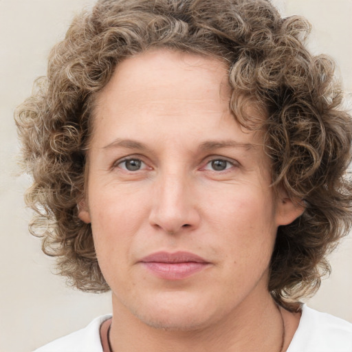 Joyful white adult female with medium  brown hair and green eyes