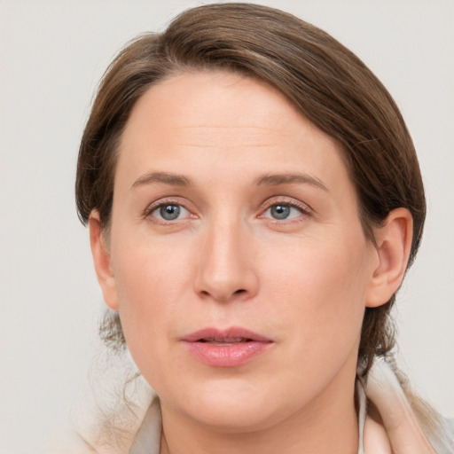 Joyful white young-adult female with medium  brown hair and grey eyes