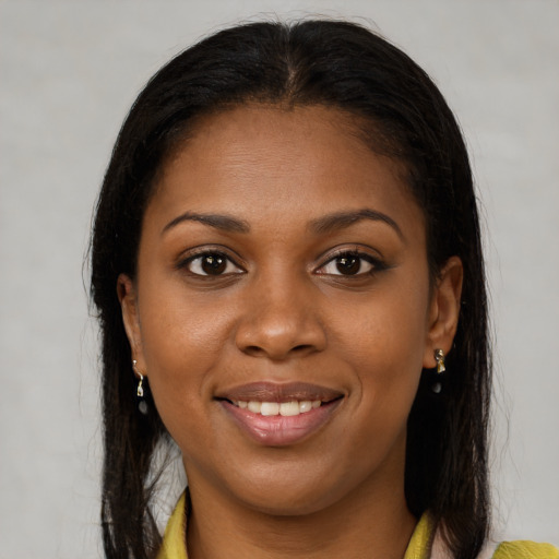 Joyful black young-adult female with long  brown hair and brown eyes