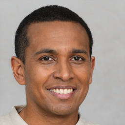 Joyful latino young-adult male with short  brown hair and brown eyes