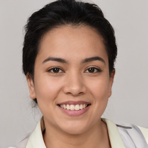 Joyful latino young-adult female with short  brown hair and brown eyes