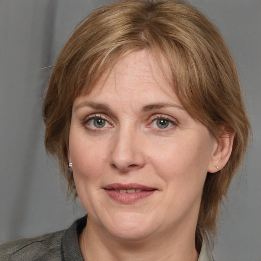 Joyful white adult female with medium  brown hair and grey eyes