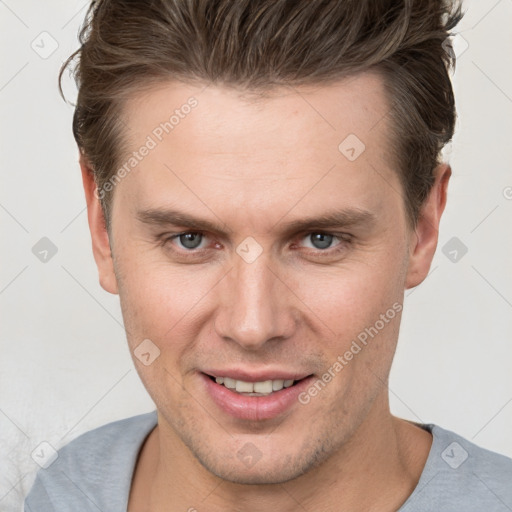 Joyful white adult male with short  brown hair and grey eyes