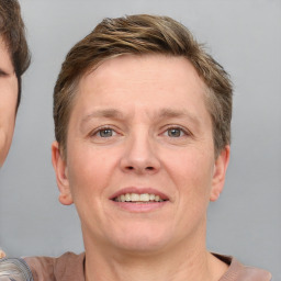 Joyful white adult female with short  brown hair and grey eyes