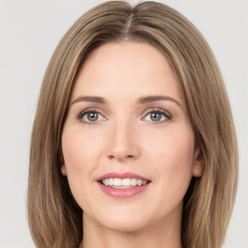 Joyful white young-adult female with long  brown hair and green eyes