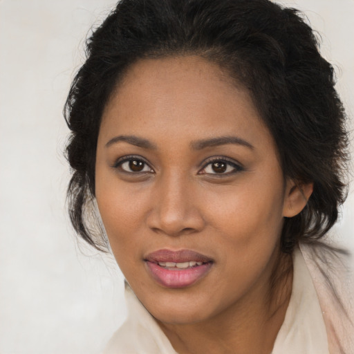 Joyful black young-adult female with long  brown hair and brown eyes