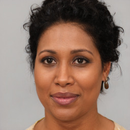 Joyful black adult female with medium  brown hair and brown eyes