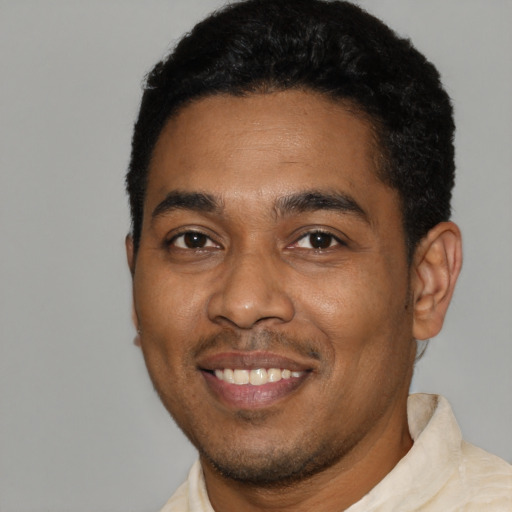 Joyful black young-adult male with short  black hair and brown eyes