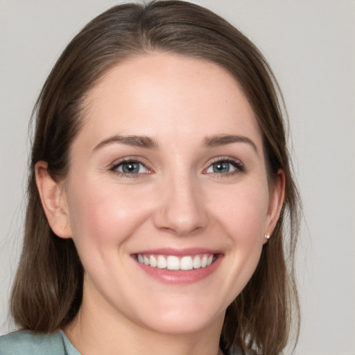 Joyful white young-adult female with medium  brown hair and grey eyes