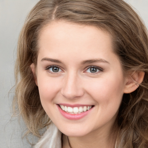 Joyful white young-adult female with long  brown hair and green eyes