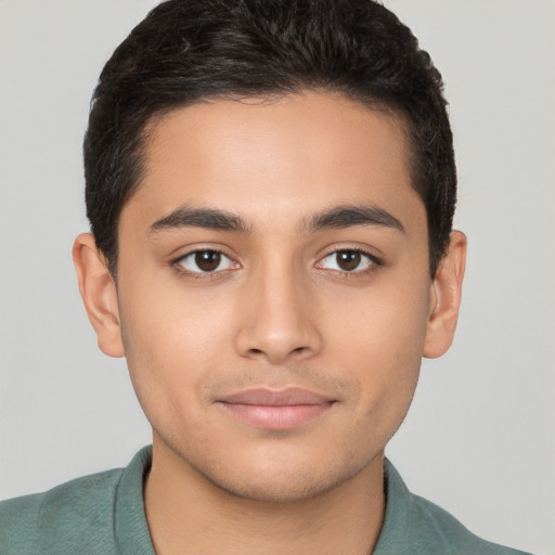 Joyful latino young-adult male with short  brown hair and brown eyes