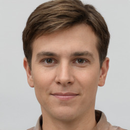 Joyful white young-adult male with short  brown hair and grey eyes