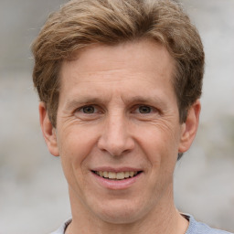 Joyful white adult male with short  brown hair and grey eyes