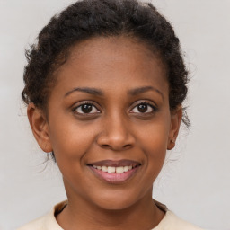 Joyful black young-adult female with short  brown hair and brown eyes