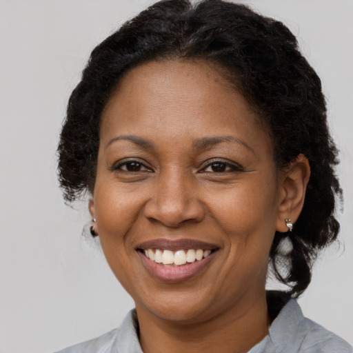 Joyful black adult female with short  brown hair and brown eyes