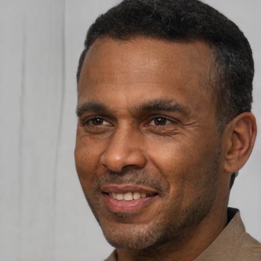 Joyful black adult male with short  brown hair and brown eyes