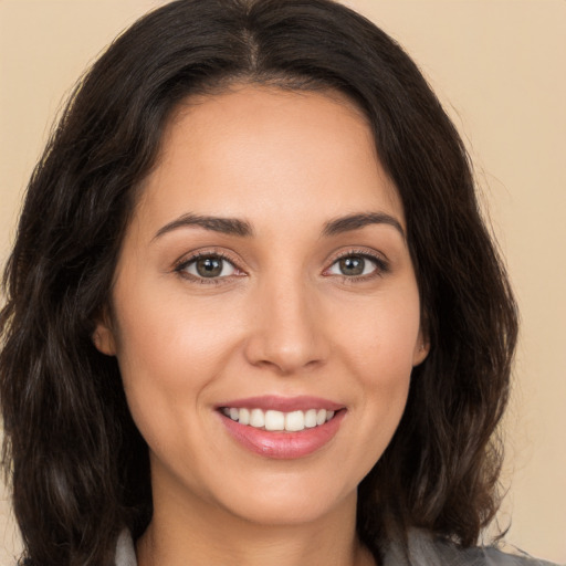 Joyful white young-adult female with long  brown hair and brown eyes