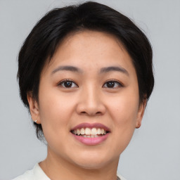 Joyful asian young-adult female with short  brown hair and brown eyes