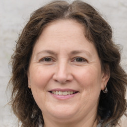 Joyful white adult female with long  brown hair and grey eyes