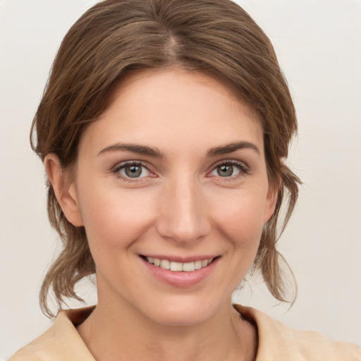 Joyful white young-adult female with medium  brown hair and grey eyes