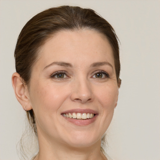 Joyful white adult female with medium  brown hair and grey eyes