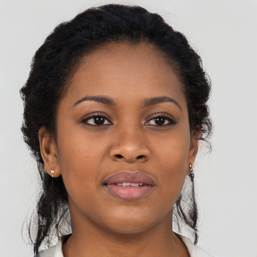Joyful black young-adult female with long  black hair and brown eyes