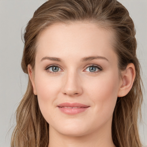 Joyful white young-adult female with long  brown hair and blue eyes