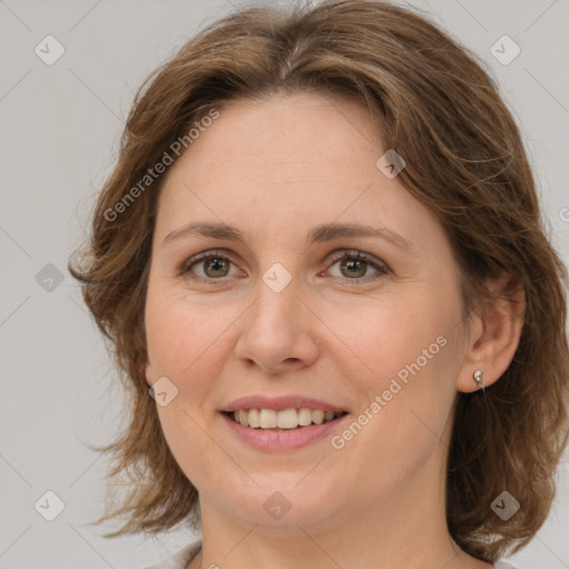 Joyful white adult female with medium  brown hair and green eyes