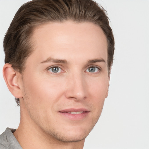 Joyful white young-adult male with short  brown hair and grey eyes