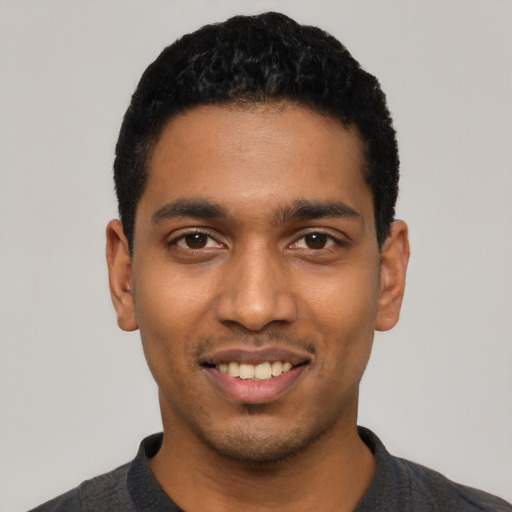 Joyful latino young-adult male with short  black hair and brown eyes