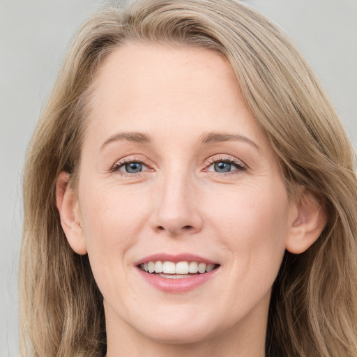 Joyful white adult female with long  brown hair and blue eyes